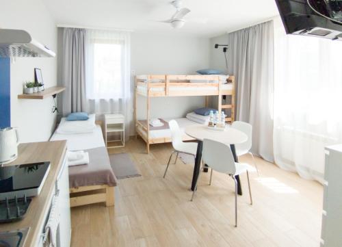 Mały pokój ze stołem, krzesłami i łóżkami piętrowymi w obiekcie Apart Hostel S8 
