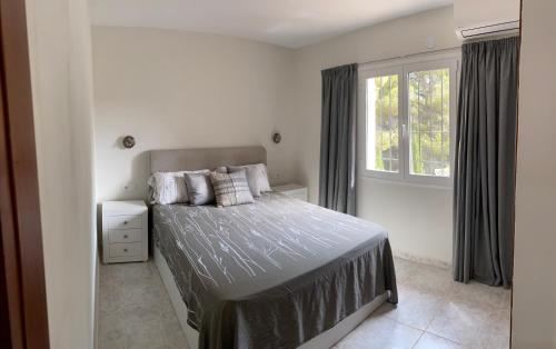 1 dormitorio con cama y ventana en Casa Koala - Bungalow in Moraira - 4 mins playa en Teulada
