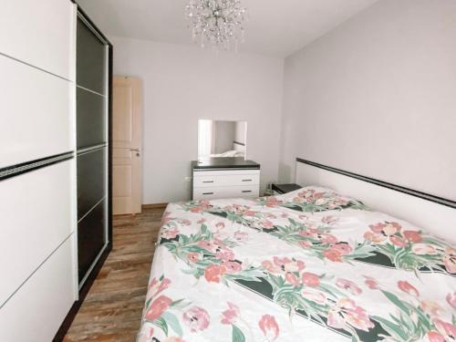 a bedroom with a bed with a floral bedspread at Cozy and spacious two bedroom apartment in Shengjin in Shëngjin
