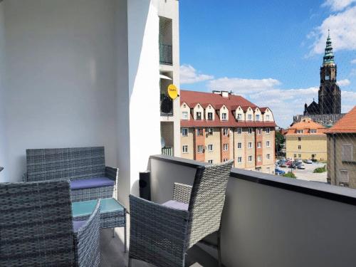 a balcony with chairs and a view of a city at Centrum Apartament Stylowy in Świdnica