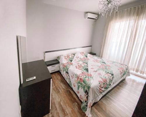 a bedroom with a bed and a desk and a window at Cozy and spacious two bedroom apartment in Shengjin in Shëngjin