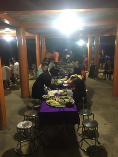a group of people sitting at a table eating food at Xuân nghi homestay in Yen Bai