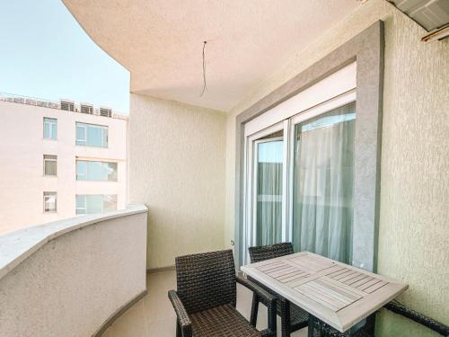 a balcony with a table and chairs and a window at Cozy and spacious two bedroom apartment in Shengjin in Shëngjin