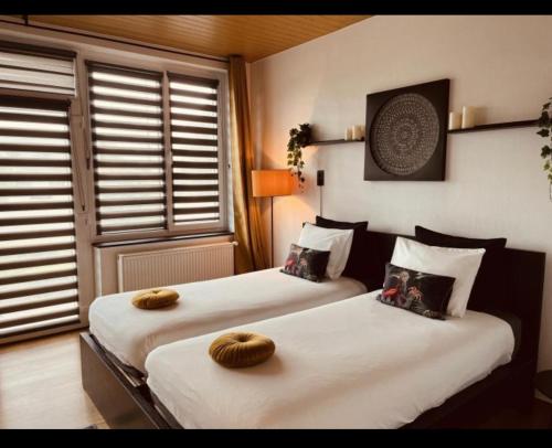Dos camas en una habitación de hotel con toallas. en La Villa Bastogne chambre d'hôtes 1 en Bastogne