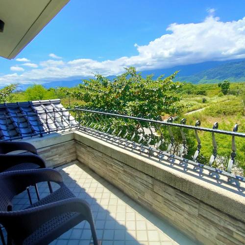 a balcony with chairs and a view of the mountains at Snail B&B in Pinghe