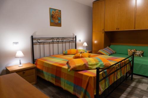 a bedroom with a bed with a colorful blanket at Zio Michele's house in Pimonte