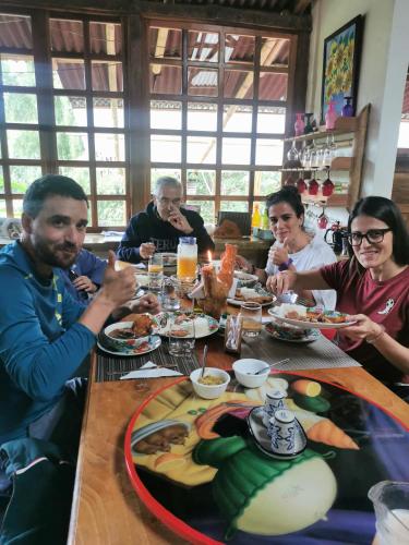 a group of people sitting around a table eating food at Finca TRADICIONAL EL OTOÑO in Pijao