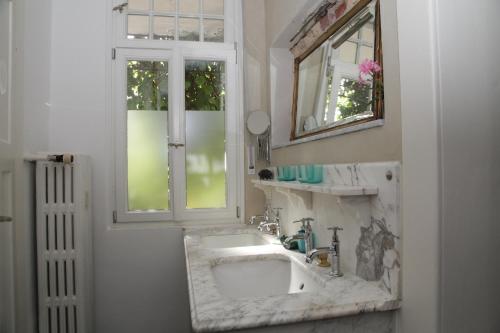 a bathroom with a marble sink and a window at Rosie's Place: Furnished Apartment with Style in Weinheim