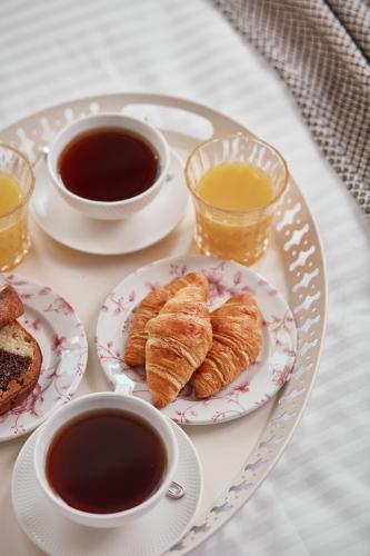 a table with plates of pastries and cups of coffee at Λιθεία-Lithia in Ioannina