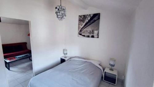 une chambre avec un lit et un tableau au mur dans l'établissement T2 meublé Toulon côte azur - 4 personnes max, à Toulon