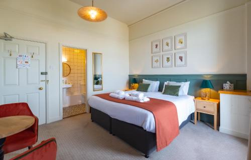 a bedroom with a large bed and a bathroom at Cliftonville Hotel in Cromer