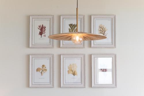 a chandelier hanging on a wall with framed pictures at Cliftonville Hotel in Cromer