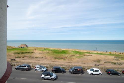 a group of cars parked on a road near the beach at Cliftonville Hotel in Cromer