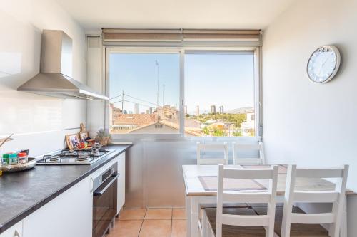 eine Küche mit einem Tisch und Stühlen sowie einem Fenster in der Unterkunft Cozy apartment in the center of Benidorm! in Benidorm