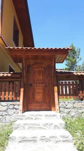 a wooden entrance to a house with a wooden door at Къща за гости Феникс in Koprivshtitsa