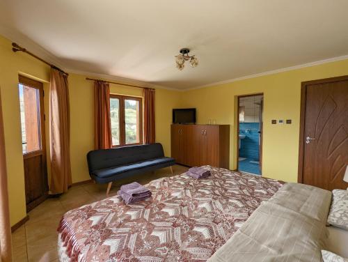 a bedroom with a bed and a chair in it at Къща за гости Феникс in Koprivshtitsa