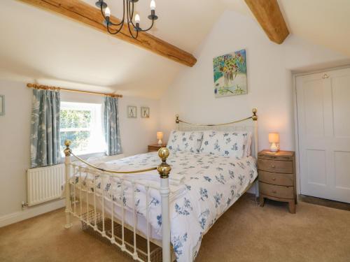 a bedroom with a white bed and a window at Hill Cottage in Matlock