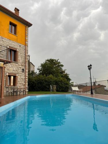 a large blue swimming pool next to a building at Affittacamere Bellavista in San Marco dei Cavoti