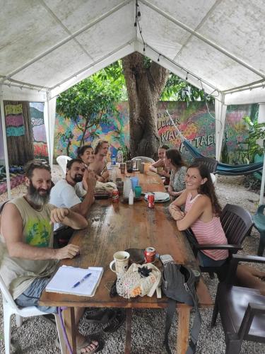 a group of people sitting around a wooden table at Hostel Matilori in Sámara