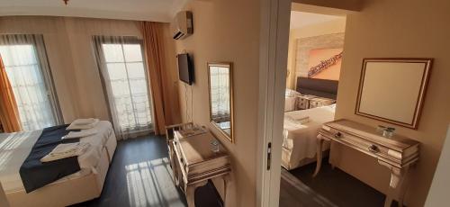 a hotel room with a bed and a mirror at Sığacık Antik Otel in Siğacık