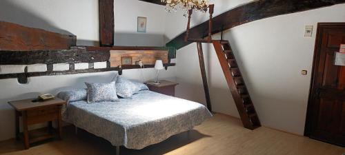 a bedroom with a large bed and a wooden staircase at Hosteria De Quijas in Quijas