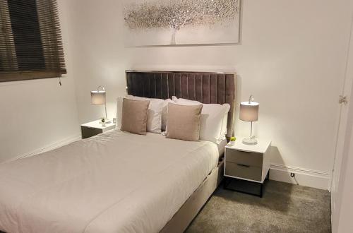 a bedroom with a bed with two night stands and two lamps at Stunning 2 bedroom apartment in Canary Wharf - Morland Apartments in London
