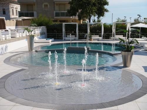 a fountain in the middle of a swimming pool at Oxygen Lifestyle Hotel in Rimini