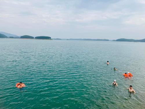 um grupo de pessoas nadando em um grande corpo de água em Xuân nghi homestay em Yen Bai