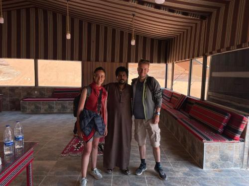 a group of three people posing for a picture at Wadi Rum Magic Camp in Wadi Rum