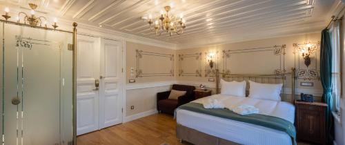 a bedroom with a bed and a chair and a chandelier at Hotel Turkish House in Istanbul