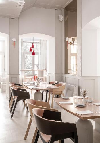 a dining room with wooden tables and chairs at Nosalowy Park Hotel & Spa in Zakopane