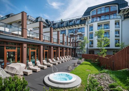 a large building with a hot tub in the courtyard at Nosalowy Park Hotel & Spa in Zakopane
