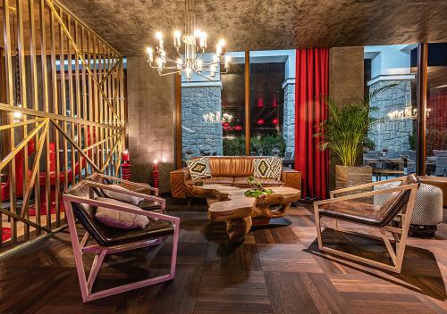a living room with a couch and chairs and a chandelier at Nosalowy Park Hotel & Spa in Zakopane