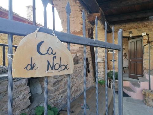 San Damiano Macra的住宿－Ca' di Nobi Podio Val Maira，建筑前有记号的标志