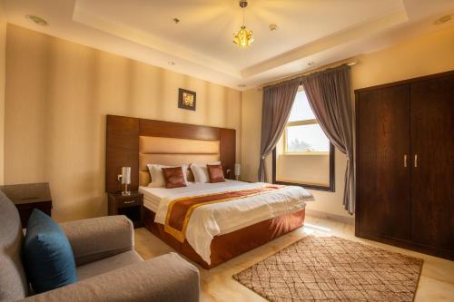1 dormitorio con 1 cama, 1 silla y 1 sofá en شقق البحر الازرق المخدومة, en Qal'at Bishah