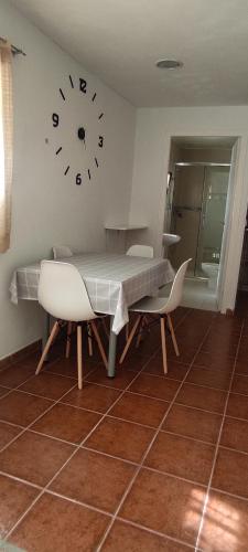 una mesa y sillas con un reloj en la pared en Ca Victor II en Arnes