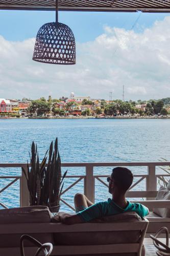 a man sitting on a couch looking out at the water at Hotel Casona del Lago in Flores