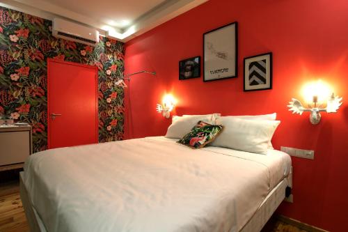 a red bedroom with a large bed with white pillows at Wynwood Boutique Hotel in Willemstad