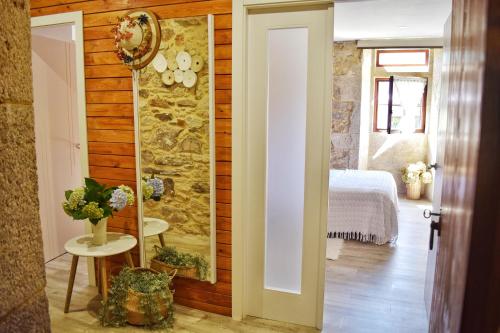 a room with a stone wall and a bedroom at Casa dos Amos en Costa da Morte. A Coruña in Ponteceso