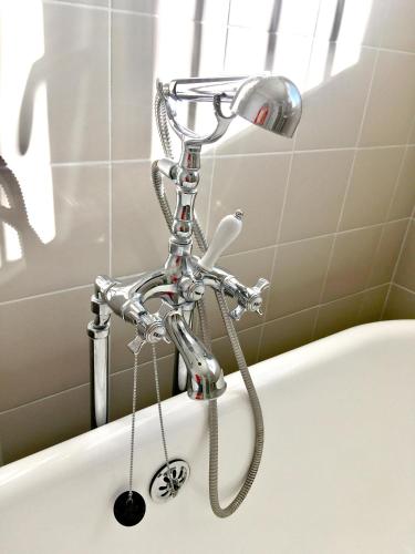 une baignoire avec un pommeau de douche et une baignoire. dans l'établissement Dans une maison, appartement indépendant et jardin, à Perpignan
