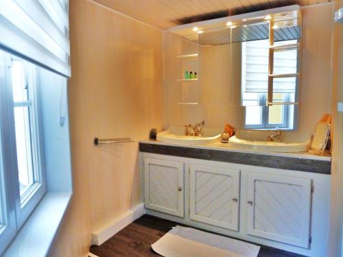 Baño con 2 lavabos y espejo en Vaste appartement, lumineux, 8 couchages, en Eaux-Bonnes