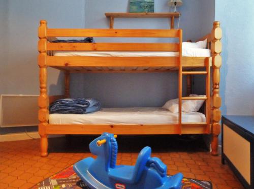 a wooden bunk bed with a blue toy in a room at Vaste appartement, lumineux, 8 couchages in Eaux-Bonnes