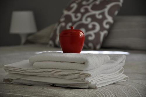 - une pile de serviettes avec une pomme sur le lit dans l'établissement Luxury Apple Room Apartment Cagliari, à Cagliari