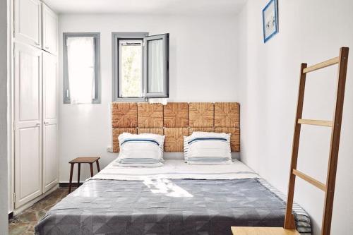 a bedroom with a bed with a wooden headboard at Villa Calypso, idyllique villa avec piscine et vue mer in Áyioi Asómatoi