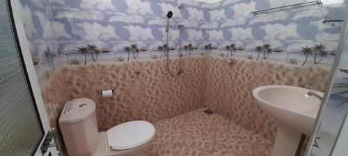 Baño pequeño con aseo y lavamanos en Paradise inn, en Kamburagalla