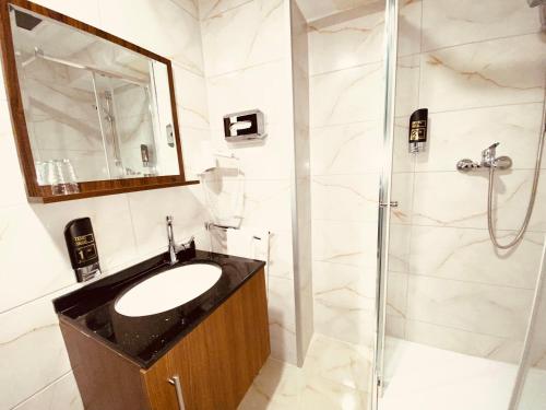 a bathroom with a sink and a shower at Louis Hotels in Schmitten