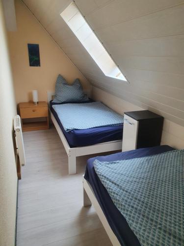 a small bedroom with two beds in a attic at Fewo-hierundjetzt Lichtenhain bei Sebnitz am Malerweg in Lichtenhain