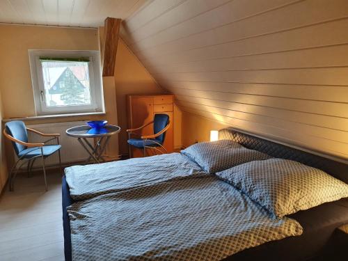 - une chambre avec un lit, une table et des chaises dans l'établissement Fewo-hierundjetzt Lichtenhain am Malerweg, à Lichtenhain