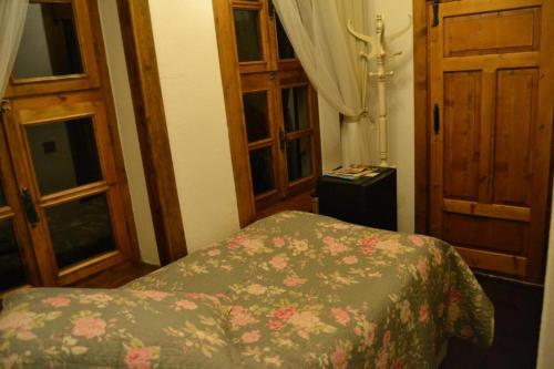 um quarto com uma cama com um cobertor florido e janelas em Aristonicus Boutique Hotel em Bergama