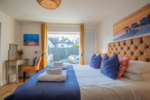 a bedroom with a large bed with blue pillows at The Beach Escapes in Hythe